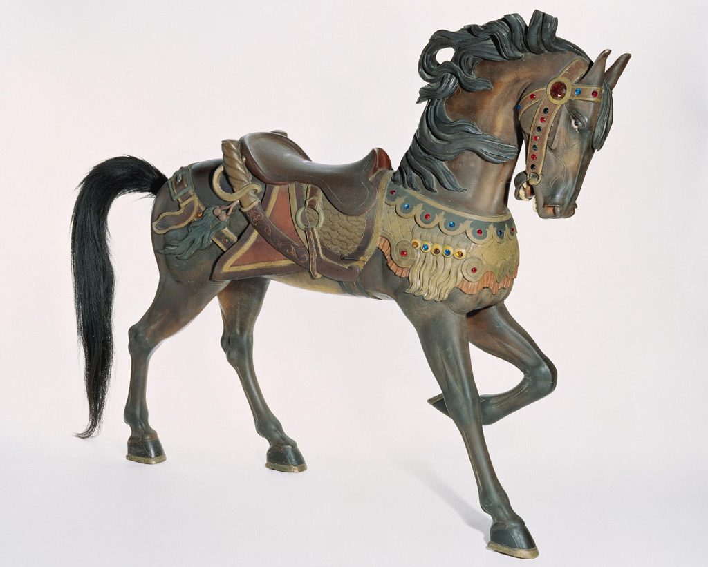 Antique carousel horse with ornate saddle, flowing mane, colorful jewels, mid-gallop.