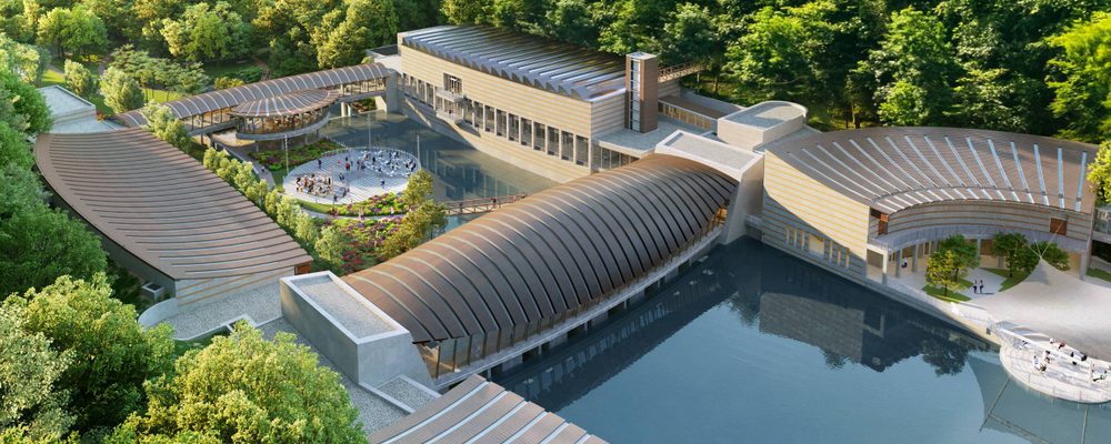 Modern architectural complex with curved roofs, trees, central plaza, water reflections.