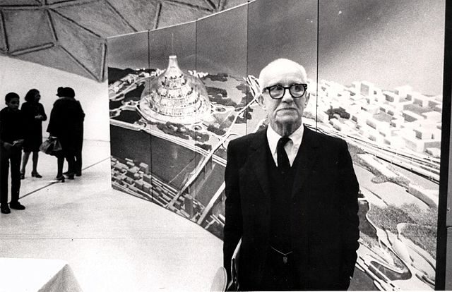 R. Buckminster Fuller stands in front of a depiction of his domed city design at its first public showing at a community meeting in East St. Louis, Illinois.