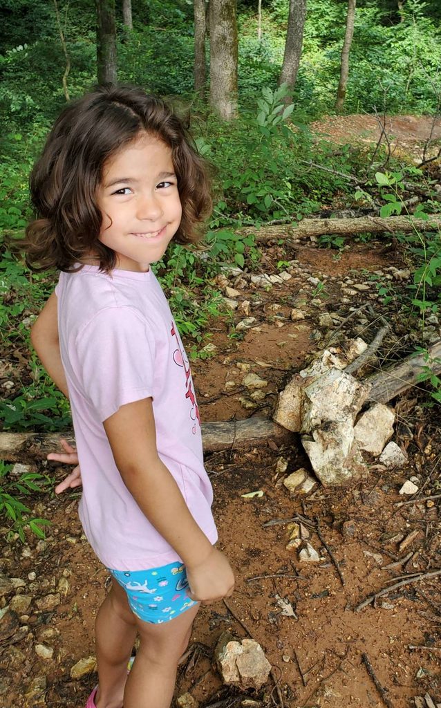 a young girl poses on the crystal bridges trails