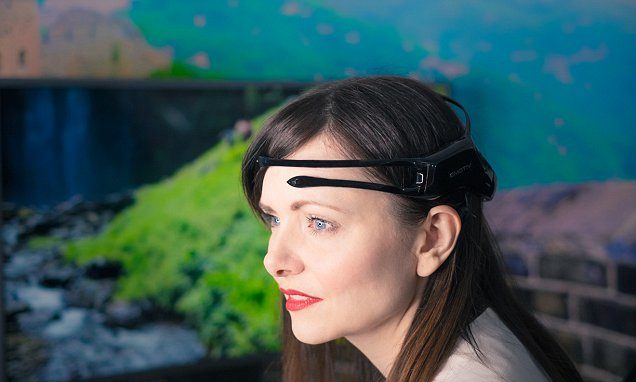 Woman with light skin and blue eyes wearing a black headband device above her eyebrows outdoors