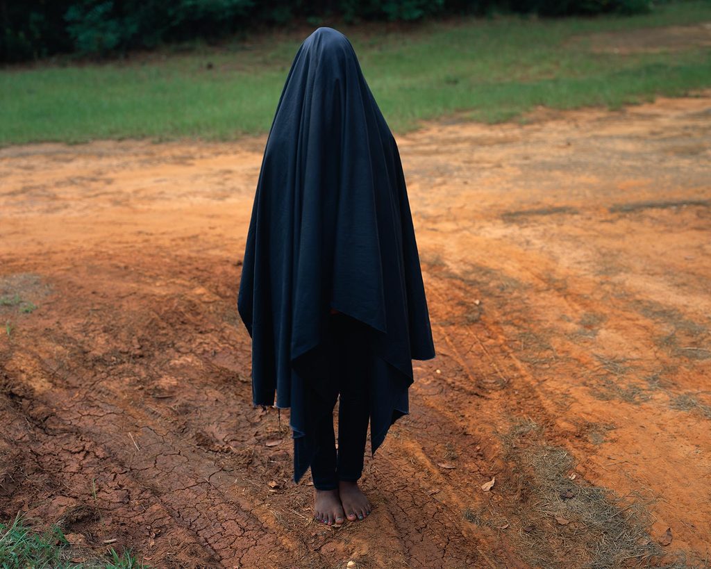 Person with a black sheet covering their body