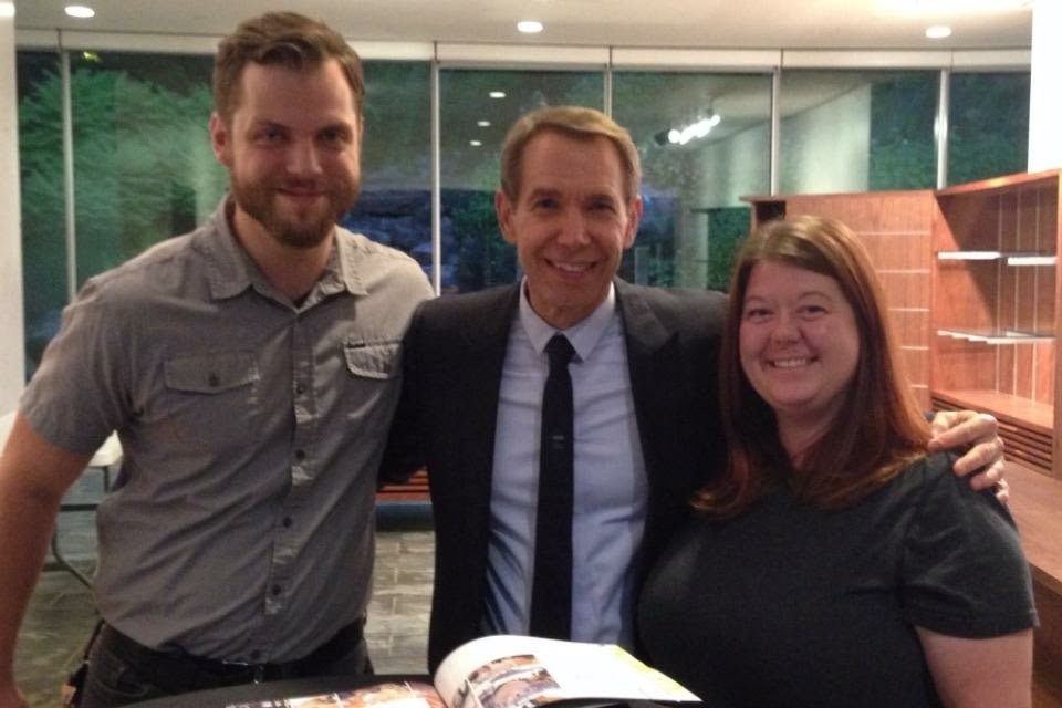 two staff members pose with artist jeff koons