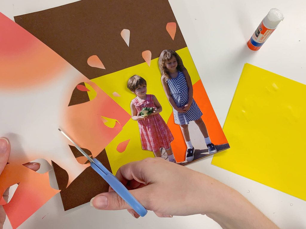 a pair of hands cutting a piece of paper with scissors