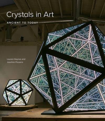 Geometric crystal-like sculptures, lit from within, in an art gallery with exposed beams.