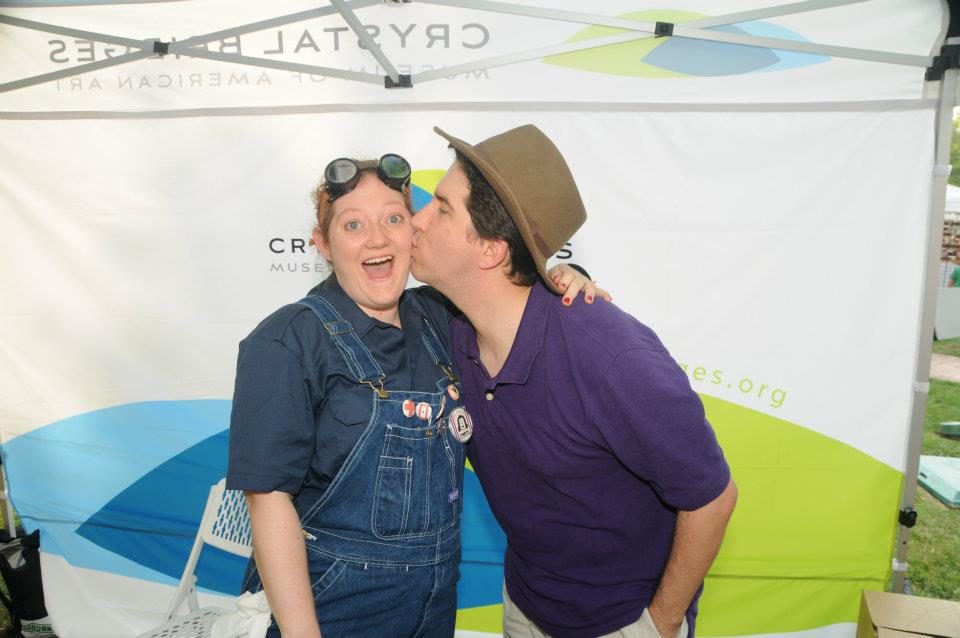 a staff member dressed as rosie the riveter receives a kiss from her husband
