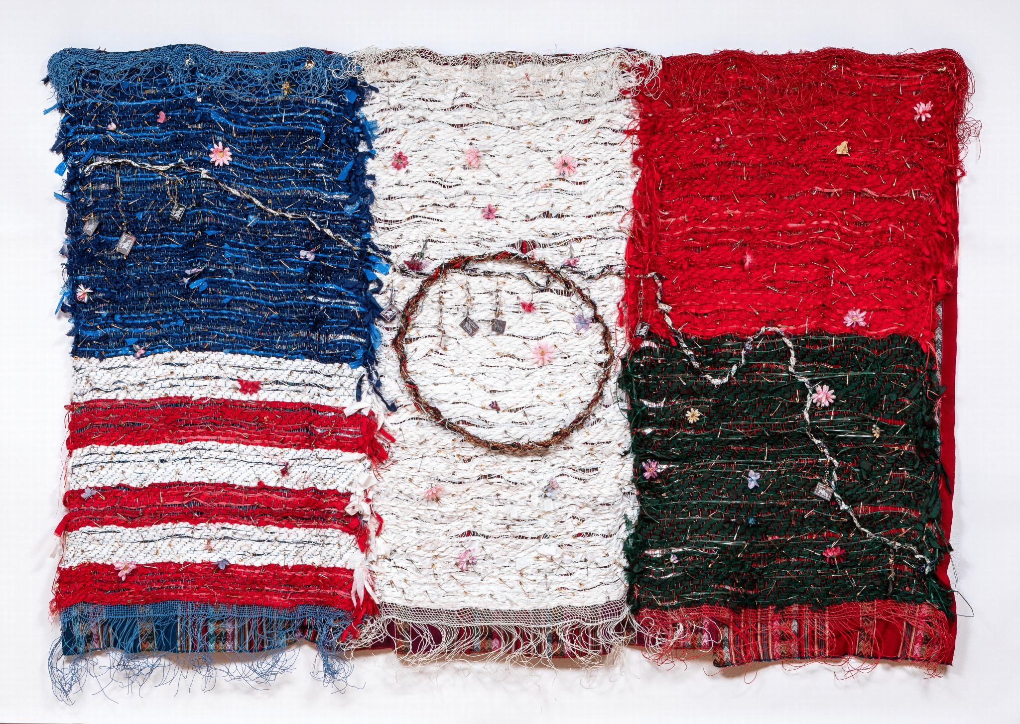 Woven textile with blue, white, and red sections; intricate designs and circular pattern.