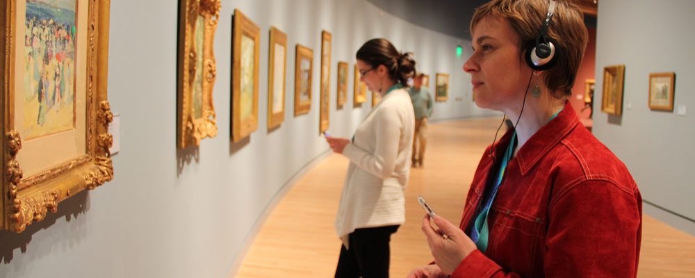 Guest listening to audio guide in gallery
