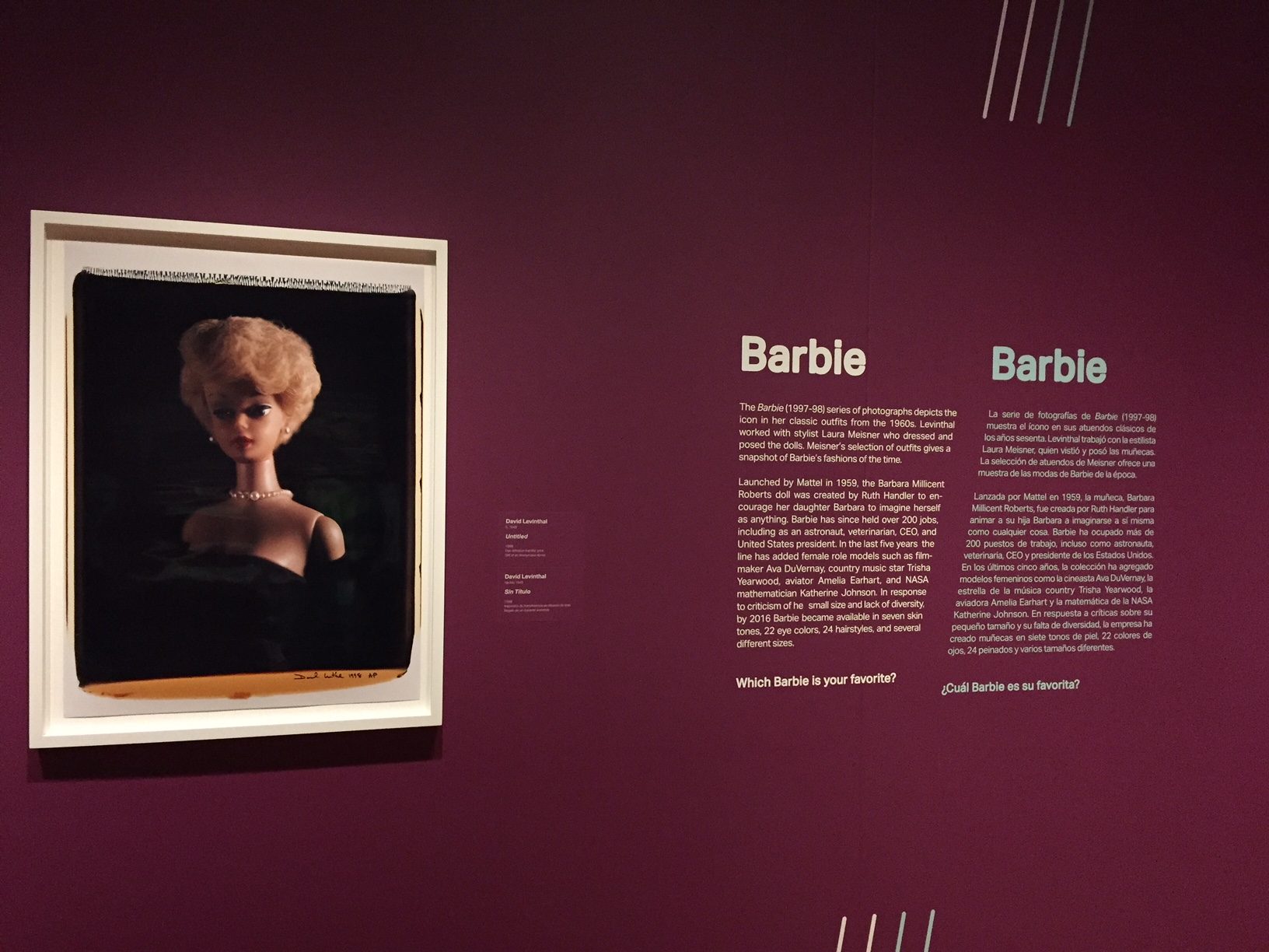 Exhibition display featuring Barbie doll photo and text on cultural significance in English and Spanish.
