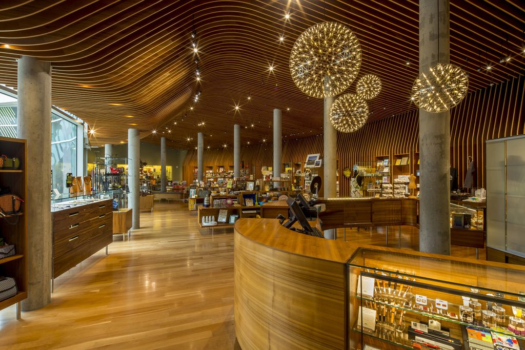 Modern retail store interior with wooden flooring, display shelves, and decorative lighting.