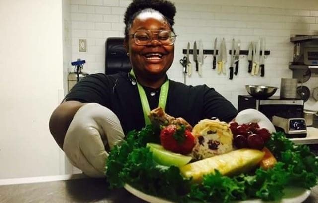 LaCameria Clark serves up a chicken salad while working with Eleven's culinary team during her internship last summer.