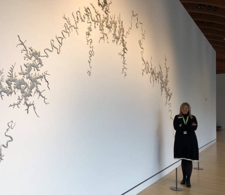 staff member poses in front of silver upper white river by maya lin
