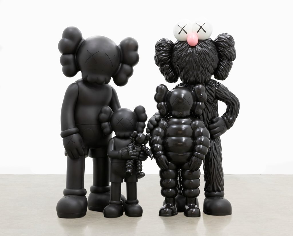 Four black sculptures depicting a family by the artist KAWS.