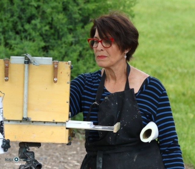 a volunteer paints a plein air painting