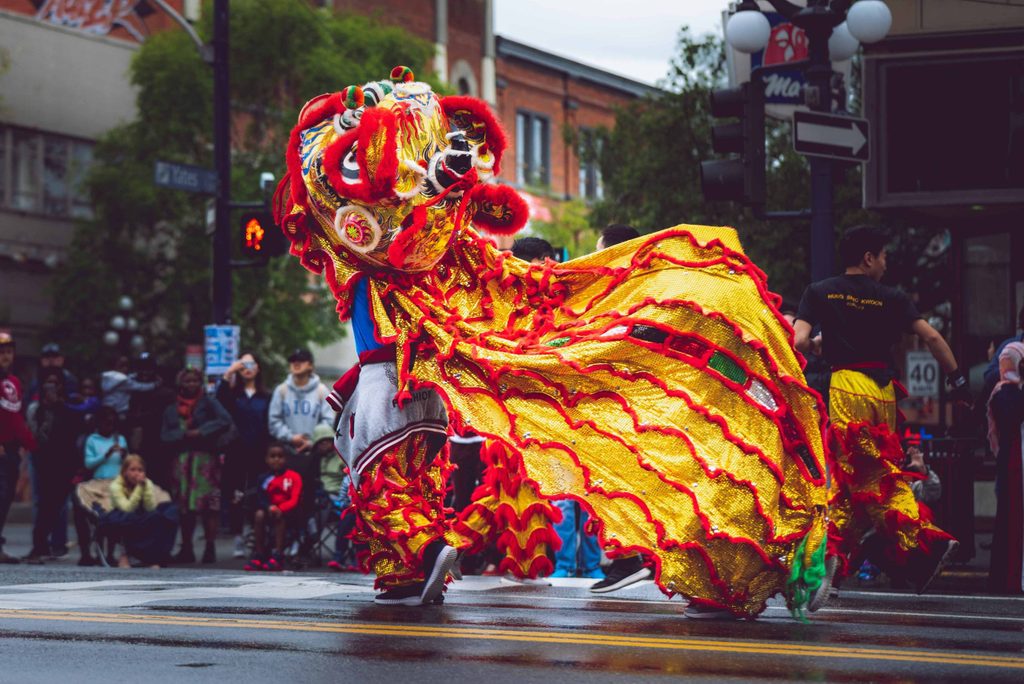 a person inside a red and yellow lion costume to celebrate lunar new year