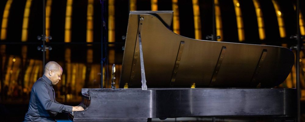 A man sitting at the Van Cliburn piano in the Crystal Bridges Great Hall