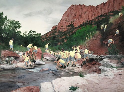 People in yellow shirts exploring rocky terrain with a stream and red rock formations.