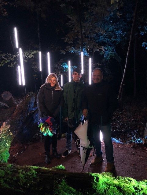 staff member poses with family in north forest lights