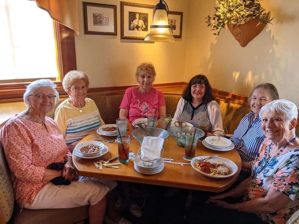 picture of guest services associate sally clifton eating lunch with five other women