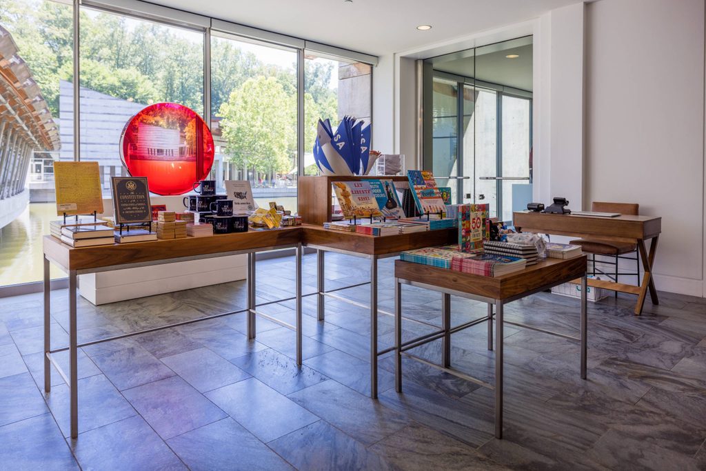 a display of museum store products on tables of differing heights near a sunny window