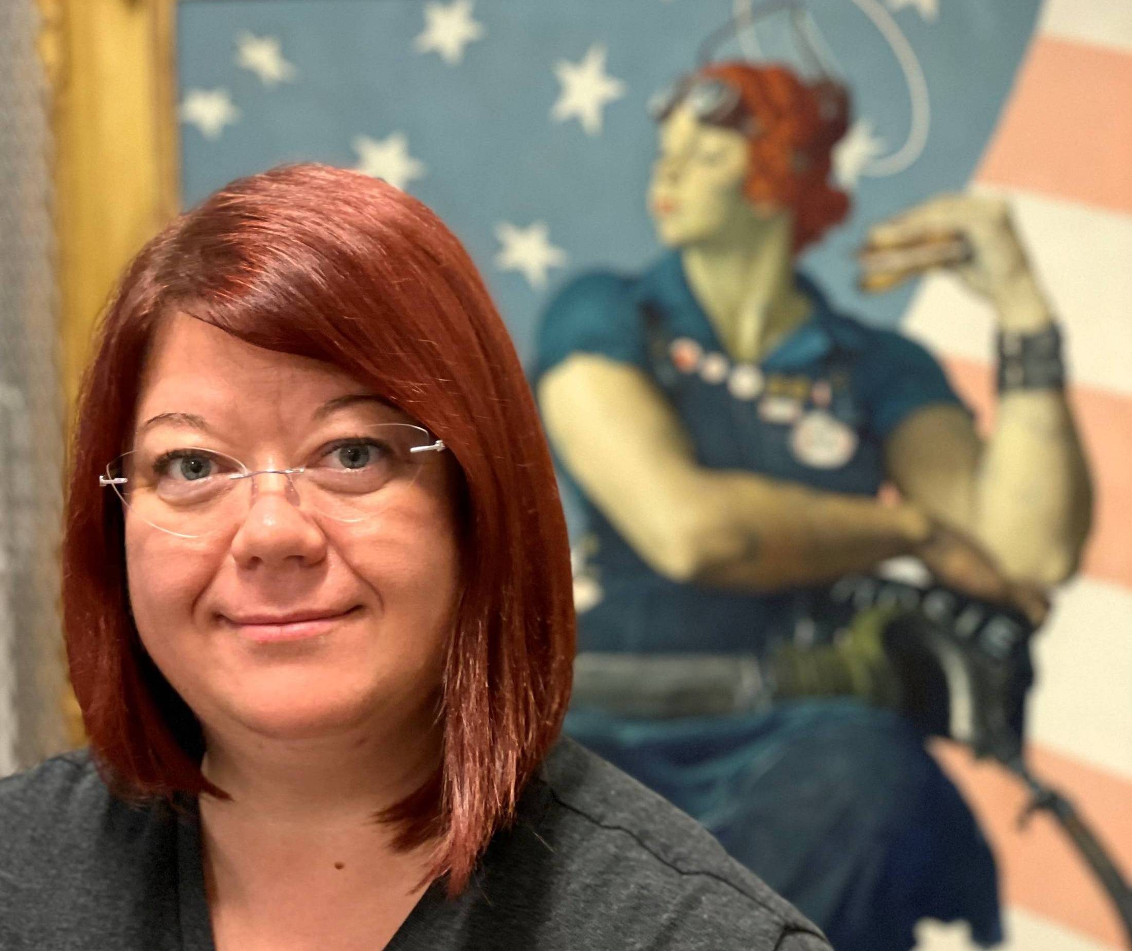 a picture of preparator trisha parker in front of rosie the riveter