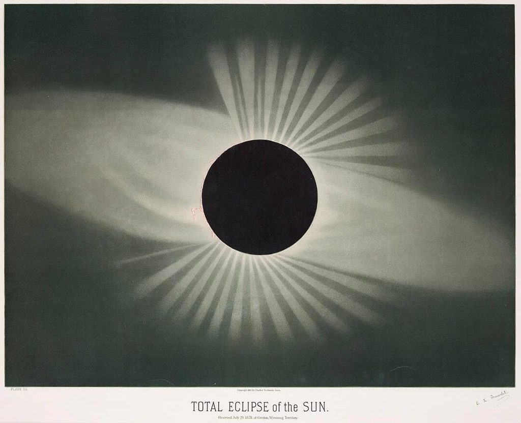 image titled “total eclipse of the sun” has a solid black circle at center with rings and rays of lights flaring out from behind it