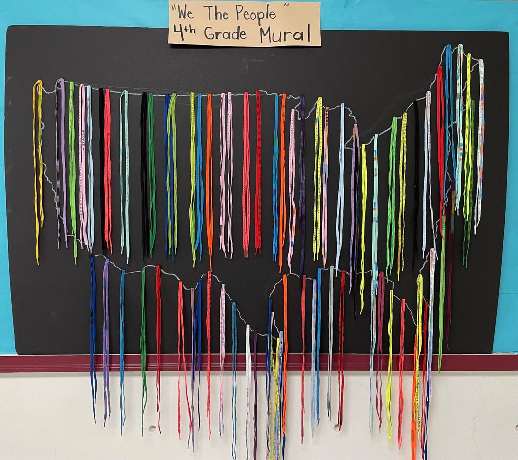 a selection of colorful shoelaces around the outline of a map of the united states beneath a sign that says 