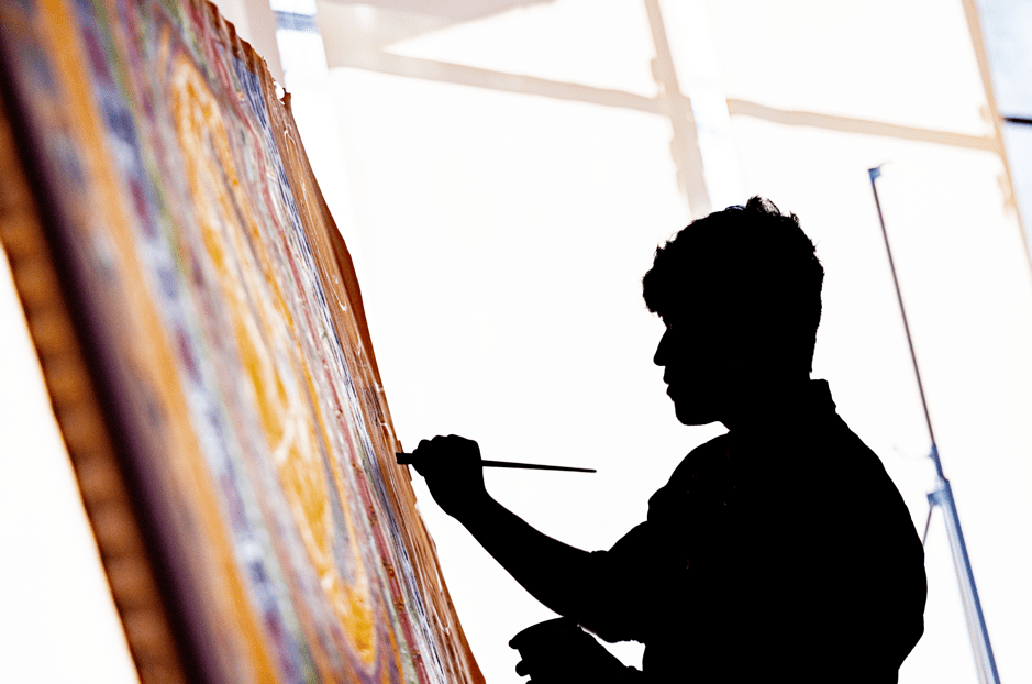 A silhouette of a teen painting a canvas at Crystal Bridges Museum of American Art.
