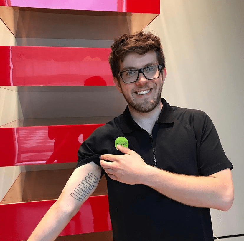 a visitor poses in front of donald judd's red untitled work in the galleries