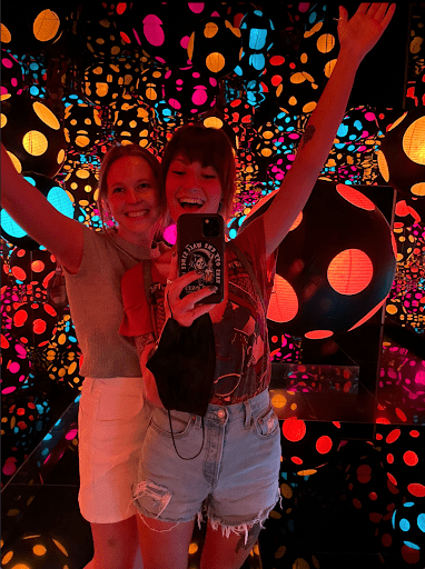 two young female visitors pose inside kusama's infinity mirrored room